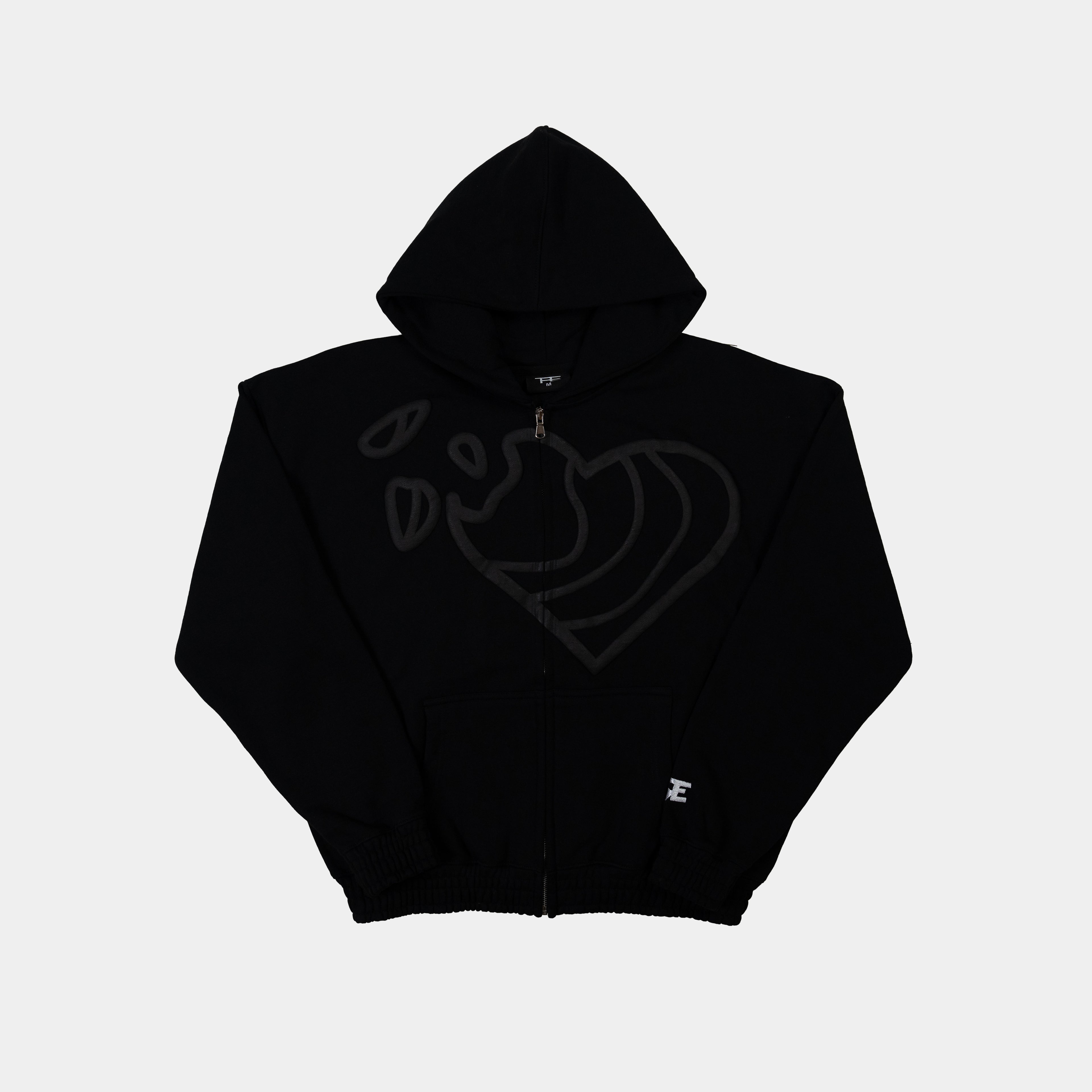 Zip Hoodie in Schwarz mit Herz Puff-Druck von Trevouse - liegen Vorne